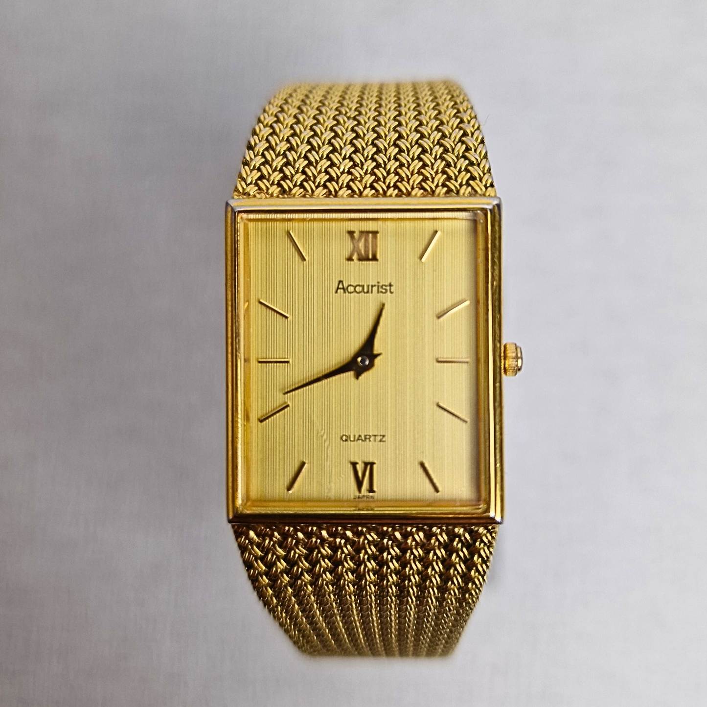 Men's vintage Accurist gold-plated tank watch with striped gold dial and quartz movement.