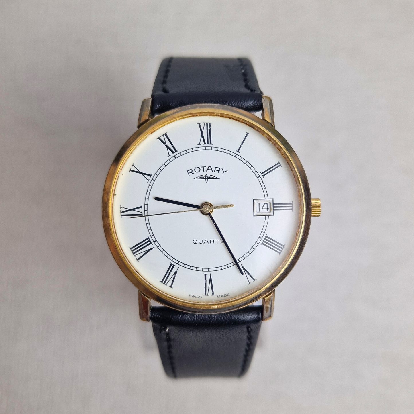 Vintage Rotary Watch Ref. 3703 371 with gold-plated case, white Roman numeral dial, and black leather strap.