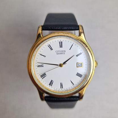 Vintage Citizen Watch Ref. 4121051 with gold-plated case, white dial, date display, and black leather strap. Classic 1980s quartz timepiece.